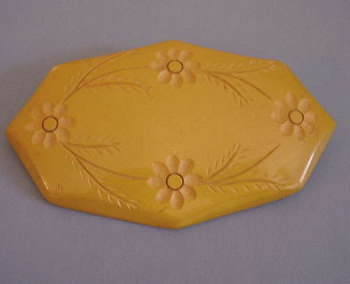 BAKELITE butterscotch brooch with carved flower design