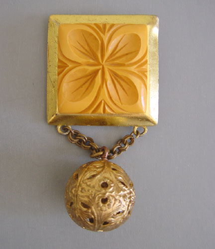 BAKELITE butterscotch carved brooch with a ball