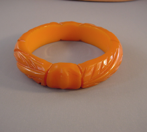 BAKELITE deep peach colored carved bangle with knots