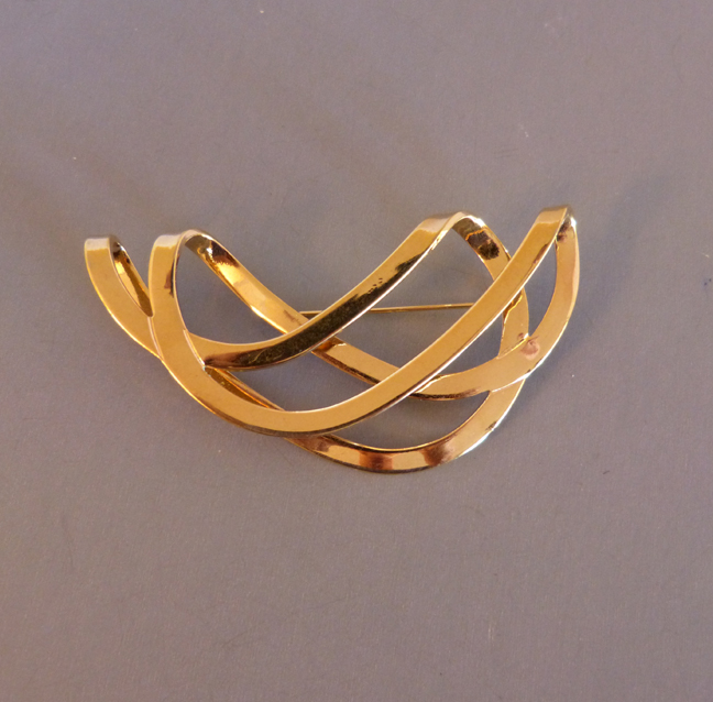 SOOTHING waves in a gold tone brooch