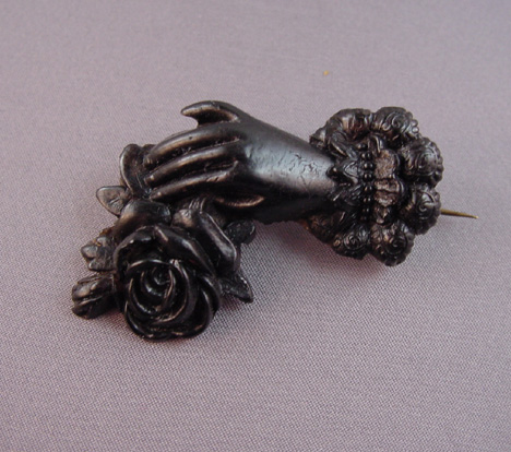 VICTORIAN vulcanite hand holding a rose brooch