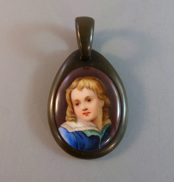VICTORIAN antique vulcanite pendant with a hand detailed transfer portrait of a child on porcelain