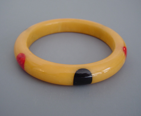 SHULTZ bakelite yellow custard swirl bangle with red & black dots