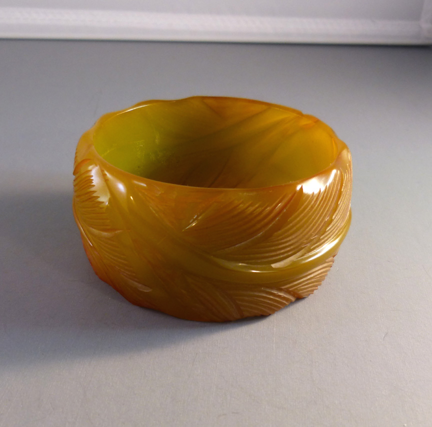 BAKELITE wide leaf carved bangle, translucent green with amber tints