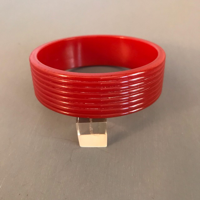 BAKELITE red flat-sided bangle with horizontally carved grooves