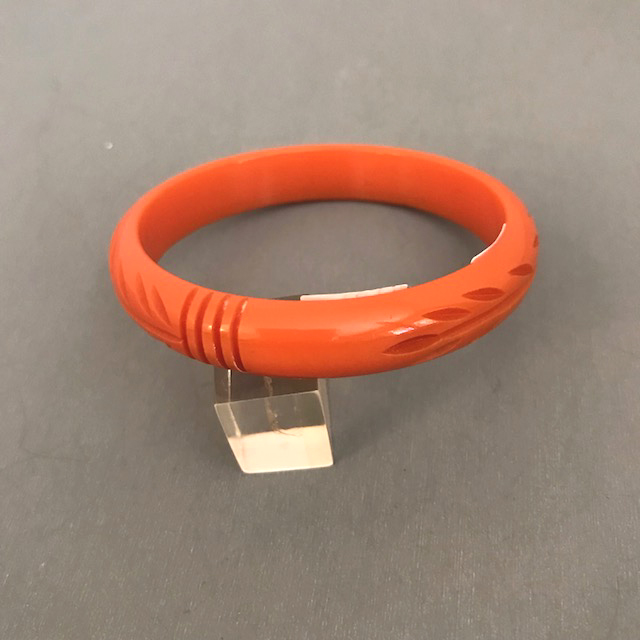 BAKELITE maiden size orange fern & lines carved bangle, 2-1/4″
