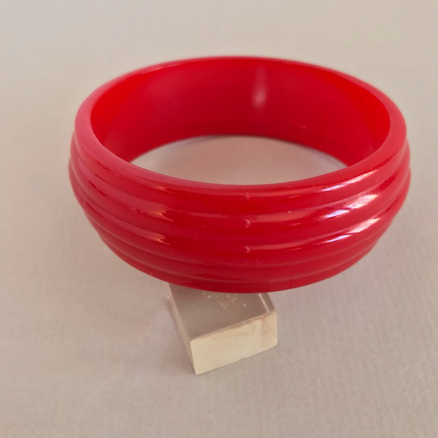 BAKELITE translucent red bangle with five rows of horizontal carving