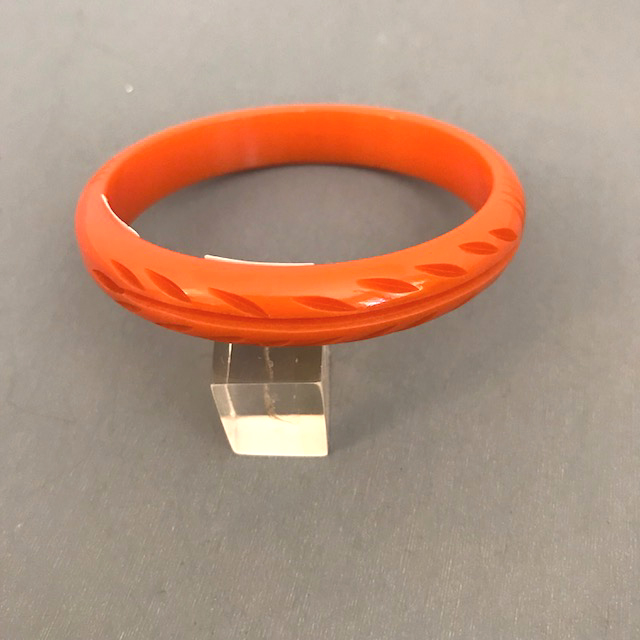 BAKELITE maiden size orange bangle carved with ferns and vertical lines