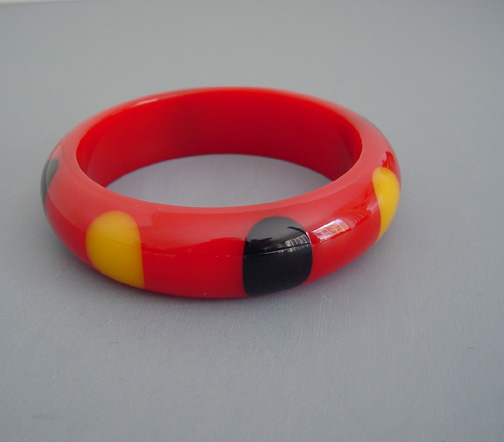 SHULTZ bakelite red bangle with eight big black and yellow dots