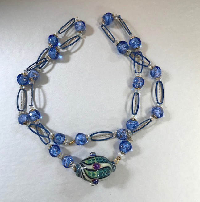 NECKLACE made of blue beads with a beautiful hand blown art glass bead in the center