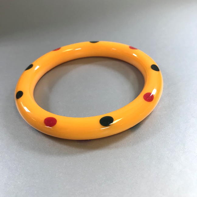 SHULTZ bakelite butterscotch tube bangle with red and blue moon side dots