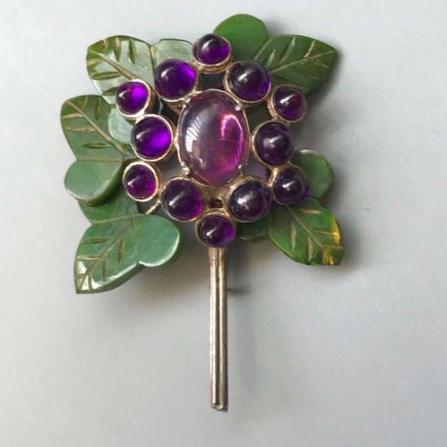 BLUMENTHAL flower brooch, oval purple center surrounded by bullet cabochons, green bakelite leaves