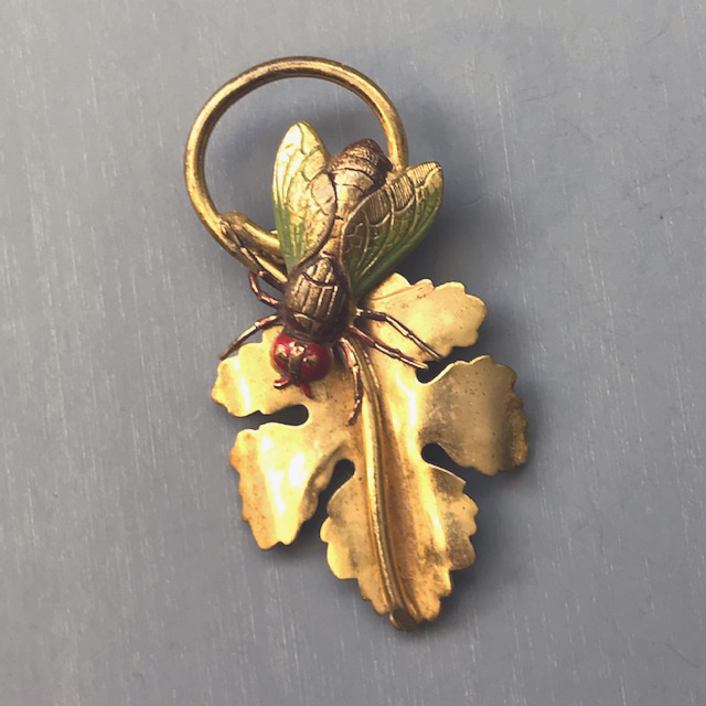 MONET bug on a leaf fur clip with a green and red enameled insect on a gold tone metal leaf