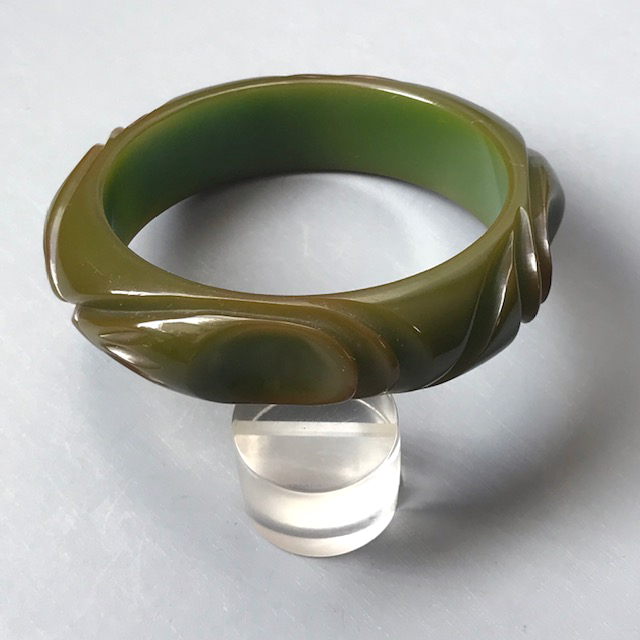 BAKELITE bangle in slightly translucent green with wonderful deep thumbprint or spoon and slash carving