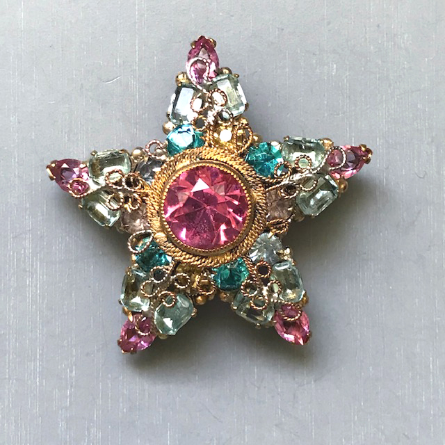 ROBERT star brooch or pendant with a pink unfoiled center rhinestone surrounded by rhinestones in aqua, pink and clear