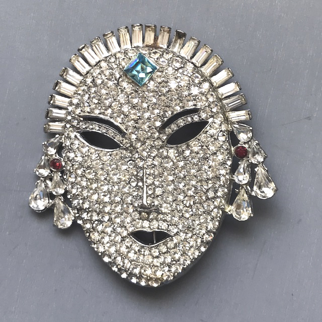 FACE or mask clear rhinestone brooch, rhodium plated setting with a pastel blue square rhinestone