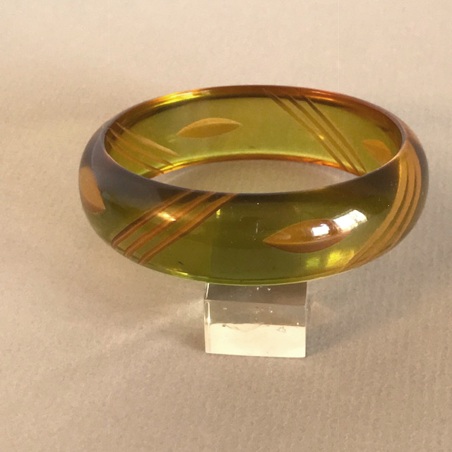 BAKELITE domed transparent green bangle with reverse carving lightly colored yellow