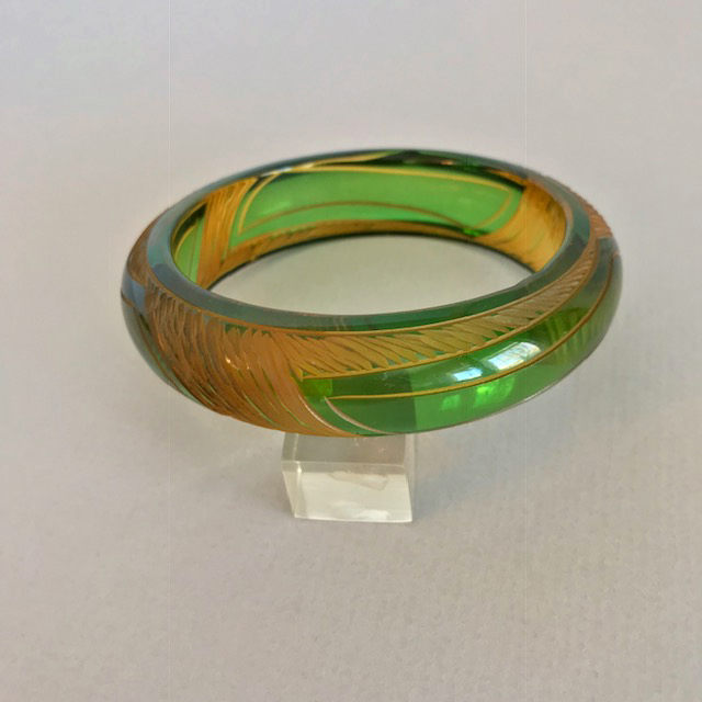 BAKELITE bangle with a transparent green dye cut to apple juice lines carved on the outside