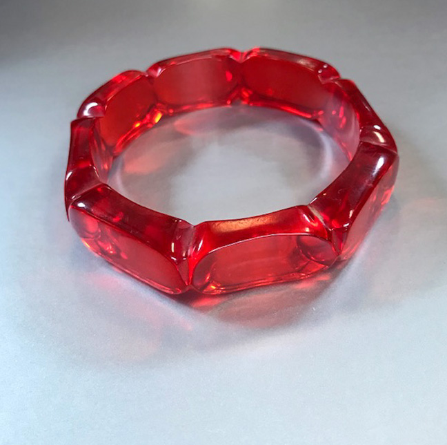 BAKELITE red transparent bangle carved with rectangular segments and brilliant red reflections