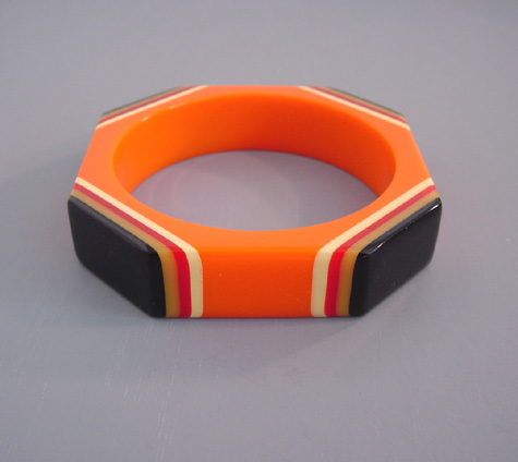 SHULTZ bakelite orange octagonal bangle with laminated corners in black, cream, red and butterscotch, very unusual