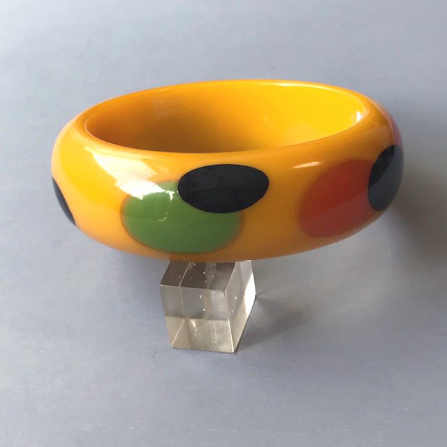 SHULTZ bakelite deep yellow bangle with overlapping dots in red black orange green,