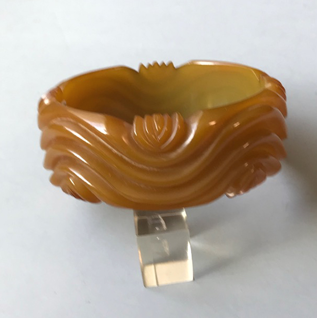 BAKELITE translucent green bangle with red tinted edges when held to the light and wonderfully wave carved