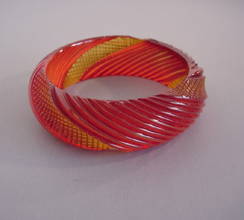 BAKELITE bangle in transparent apple juice over dyed in red, wonderful cross hatched and diagonal carving