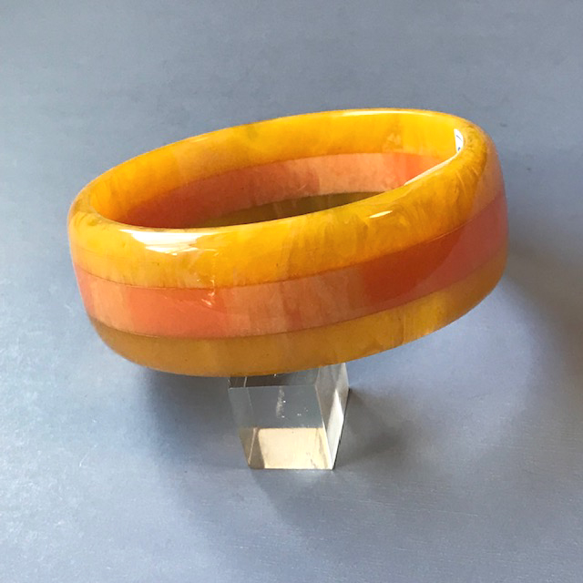 SHULTZ bakelite laminated three row bangle with a citrus orange marbled center stripe and two marbled lemon yellow bands