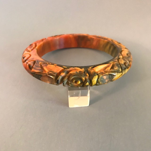 BAKELITE bangle, a deeply carved end-of-day orange with lots of tan, yellow and black marbling