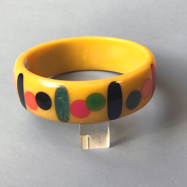SHULTZ bakelite butterscotch bangle with long oval and round dots in several colors