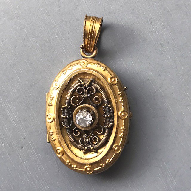VICTORIAN revival yellow gold filled locket with a clear paste or rhinestone in the center front surrounded by circles and scrolls