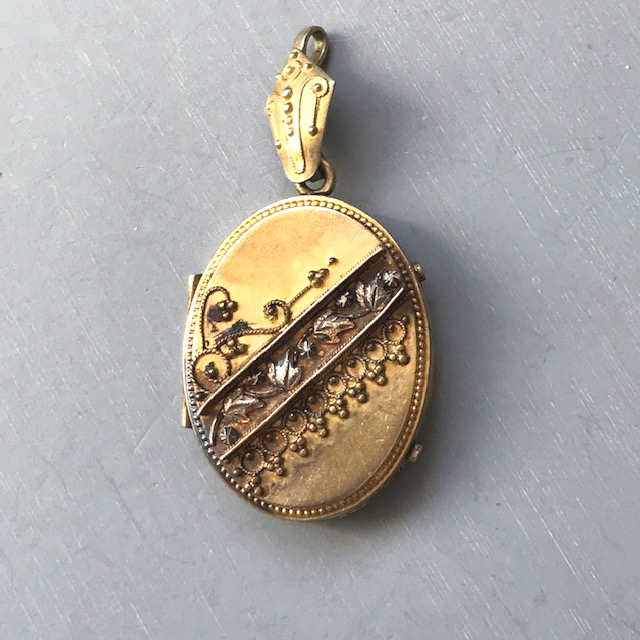 LOCKET Victorian revival locket with a raised band of leaves across the front with applied fleur-de-lis and scrolls