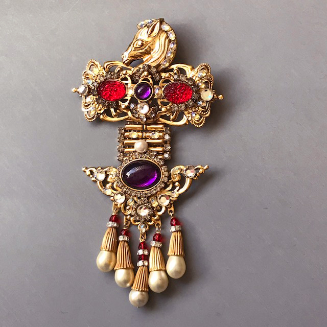 LARRY VRBA hinged brooch with a golden horse head at the top, wonderful red textured stones and purple cabochons