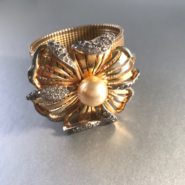 DEROSA gold plated mesh bracelet with a center flower decorated with a glass pearl and clear rhinestones