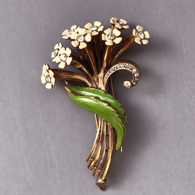 DEROSA fur clip with a bouquet of delicate enameled cream colored flowers with clear rhinestone centers and long green leaves