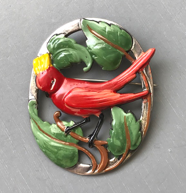 CORO sterling silver brooch with a two-tone red enameled bird sporting a jaunty yellow crest surrounded by lovely green leaves