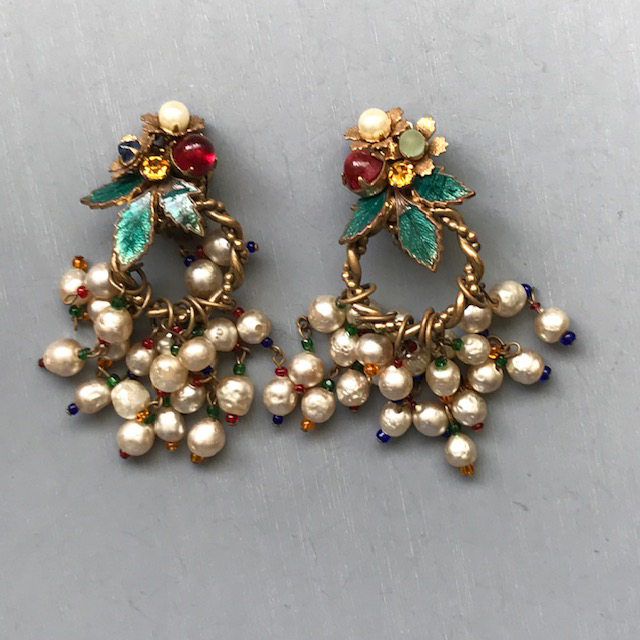 MIRIAM HASKELL earrings with an abundance of colorful glass beads and costume pearls suspended from the top, which is decorated with rhinestones, cabochons and green enameled leaves