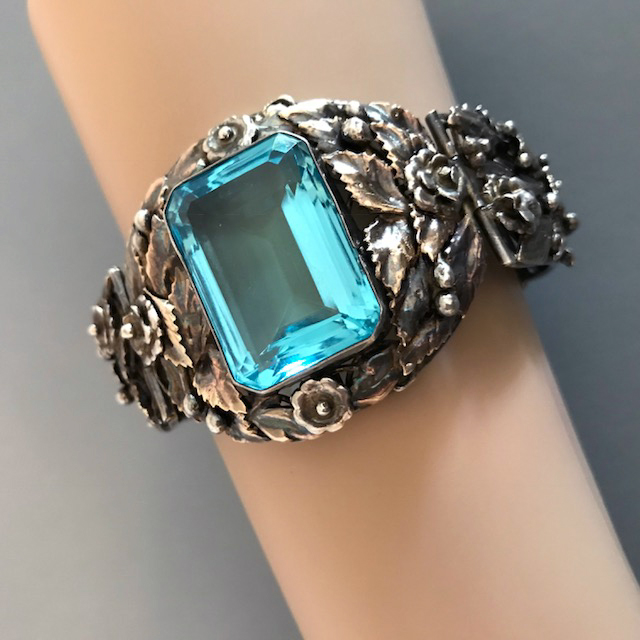 HOBE sterling silver bracelet with a brilliant rectangular aqua blue unfoiled center rhinestone surrounded by intricate hand wrought sterling flowers, leaves and beads