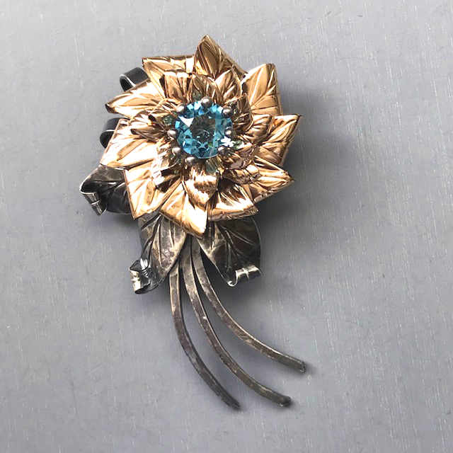 HOBE aqua rhinestone flower brooch in sterling silver with 14k gold plated accents, hand wrought to form the lots of petals and leaves