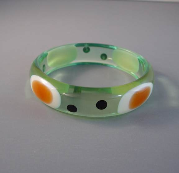 SHULTZ bakelite transparent aqua-green bangle with oval bull’s eye dots in marbled caramel and white along with smaller round black dots