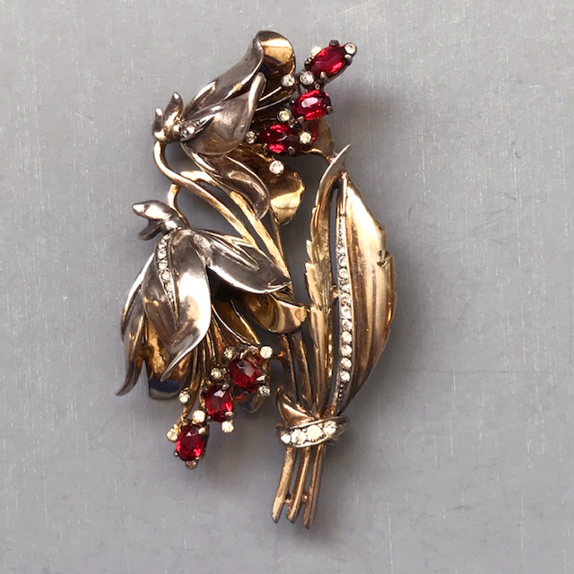 DEROSA bell flowers brooch with red rhinestone stamen and clear rhinestone accents in a gold plated setting