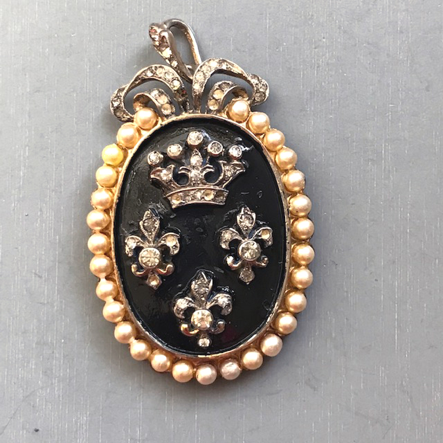 DEROSA regal brooch enameled black oval has a crown, three fleur-de-lis with clear rhinestones and glass pearls