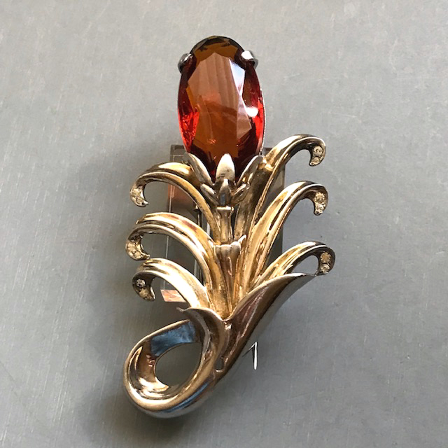 DEROSA stylized “flower” fur clip with a red-amber colored large oval rhinestone in a gold plated sterling silver setting with tiny clear rhinestone accents