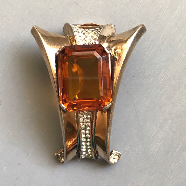 DEROSA fur clip with a topaz colored faceted glass rectangular rhinestone center and clear rhinestones accents in a gold plated sterling silver setting
