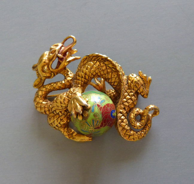 CHINESE Blumenthal style large dragon brooch with a gold metal dragon figure wrapped around a cloisonne ball done in green, cinnabar red, navy blue and aqua, substantial size 3″