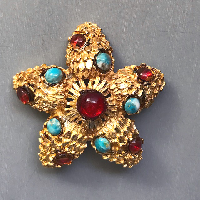 STARFISH brooch with red and aqua glass cabochons in a heavily textured gold setting