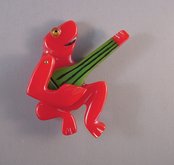 SHULTZ bakelite red frog musician brooch with a swivel arm playing a green banjo