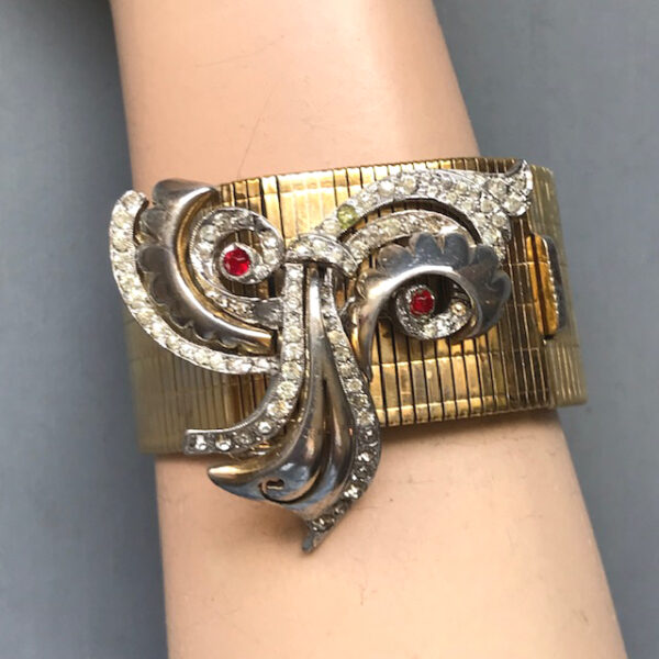 DEROSA attributed very unusual bracelet with a red and clear rhinestone swirling center element on the front of a wide gold plated mesh band