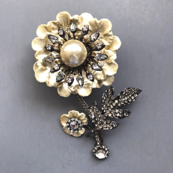 LARRY VRBA pearlized flower brooch with two layers of pearlized rippled petals, a round pearlized center and teardrop-shaped clear rhinestone halo