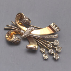 MAZER retro brooch with a ribbon design and a spray of clear rhinestones in gold plated sterling silver, 1940s